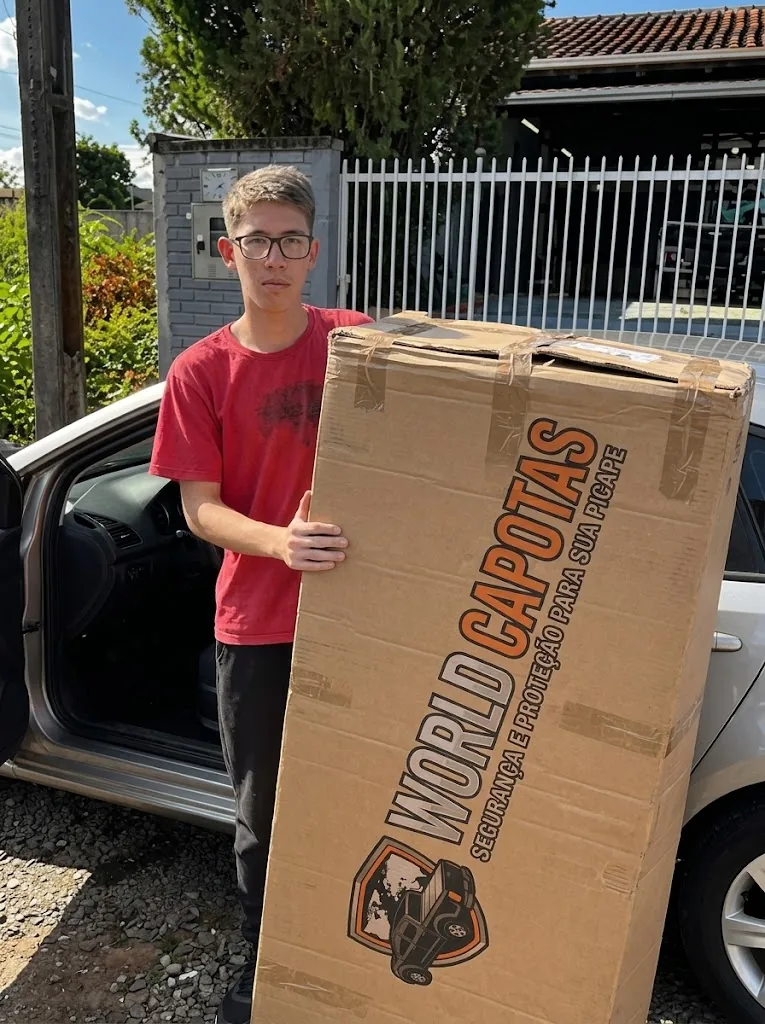 Cliente de camiseta vermelha com a embalagem do pedido World Capotas